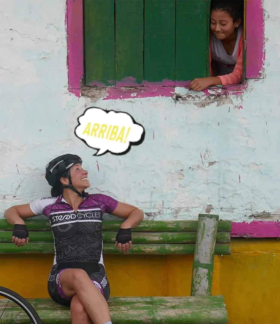 american female cyclist talking whit a colombin girl