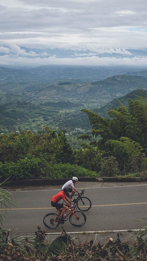 American and Colombian cyclist riding in Alto de letras 